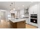 Modern kitchen with a large island, quartz countertops, stainless steel appliances, and custom cabinets at 3912 Cedar Knolls Dr, Youngsville, NC 27596