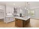Charming kitchen with custom cabinets, quartz countertop island, stainless steel appliances, and hardwood floors at 3912 Cedar Knolls Dr, Youngsville, NC 27596