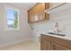 Functional laundry room with ample cabinet space, sink, and a window for natural light at 3912 Cedar Knolls Dr, Youngsville, NC 27596