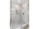Large walk-in shower featuring marble-like tile, updated showerhead, and built-in shelving at 3912 Cedar Knolls Dr, Youngsville, NC 27596