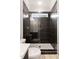 Contemporary shower with sleek, dark tiling, gold hardware, and a window for natural light at 3912 Cedar Knolls Dr, Youngsville, NC 27596
