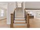 Grand staircase with wood treads, sleek iron railings, and a view into the open kitchen at 3912 Cedar Knolls Dr, Youngsville, NC 27596