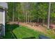 Manicured backyard with a green lawn, mature trees, and tasteful landscaping at 7320 Dunsany Ct, Wake Forest, NC 27587