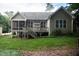 Backyard view showcasing a deck, screened porch, and manicured lawn at 7320 Dunsany Ct, Wake Forest, NC 27587
