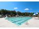 A pristine swimming pool awaits, surrounded by lounge chairs, umbrellas, and fun aquatic activities at 7320 Dunsany Ct, Wake Forest, NC 27587