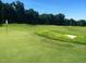 A well-manicured green golf course offers manicured lawns, sand traps, and distant trees under a clear blue sky at 7320 Dunsany Ct, Wake Forest, NC 27587