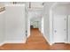 Long hallway with hardwood floors, white trim, and views into the living room with a fireplace at 7320 Dunsany Ct, Wake Forest, NC 27587