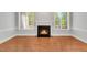 Bright living room featuring a fireplace, hardwood floors, and large windows for plenty of natural light at 7320 Dunsany Ct, Wake Forest, NC 27587