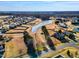Beautiful aerial view of a neighborhood featuring a pond and well-maintained homes with lush lawns under a bright blue sky at 8217 Cannon Grove Dr, Willow Springs, NC 27592