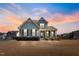 Charming two-story home at dusk featuring a welcoming front porch and manicured front yard at 8217 Cannon Grove Dr, Willow Springs, NC 27592
