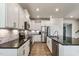 Modern kitchen with white cabinets, stainless steel appliances, and granite countertops, perfect for cooking at 8217 Cannon Grove Dr, Willow Springs, NC 27592