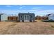A backyard shed with double doors offers extra storage and workspace, set against a sunny sky at 8217 Cannon Grove Dr, Willow Springs, NC 27592