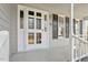 White front door with glass panes and black shutters, leading to a cozy front porch at 101 Stefi Ct, Garner, NC 27529