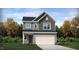 Two-story home with gray siding, white garage door, and landscaping at 1139 Atterlee Ln, Graham, NC 27253