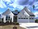 Charming one-story white brick home with a two-car garage, a landscaped front yard and a blue sky at 200 Regency Ridge Dr, Holly Springs, NC 27540