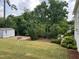 Spacious backyard featuring a shed, deck, fire pit, and lush green lawn at 317 Compton Rd, Raleigh, NC 27609