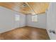 Basement room with wood ceiling, hardwood floors, and door at 317 Compton Rd, Raleigh, NC 27609