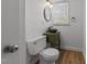 Small bathroom with pedestal sink, toilet, and wood floor at 317 Compton Rd, Raleigh, NC 27609