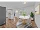 Cozy eat-in kitchen with a white marble table, wood floors, white cabinets, and stainless steel refrigerator at 317 Compton Rd, Raleigh, NC 27609