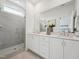 Bright bathroom with dual sink vanity, glass enclosed shower, and a large mirror at 524 Billingshurst Way, Knightdale, NC 27545