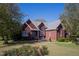 Brick home with landscaping, large yard, and a spacious front porch at 555 House Rd, Kenly, NC 27542