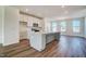 Bright kitchen featuring white cabinets, stainless appliances, large gray island, and hardwood flooring throughout at 861 Parc Townes Dr # 6, Wendell, NC 27591