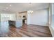 Living room adjacent to the kitchen with hardwood floors and modern chandelier at 861 Parc Townes Dr # 6, Wendell, NC 27591