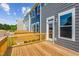 Back deck overlooking community and trees with wood-grain flooring and a wooden rail at 867 Parc Townes Dr # 3, Wendell, NC 27591