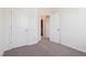 Carpeted room with an open door, a closet door, and white walls creates a modern living space at 867 Parc Townes Dr # 3, Wendell, NC 27591