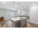 Open concept kitchen with island, pendant lighting, and seamless flow into the living area at 1008 Ashton Oak Ct, Durham, NC 27703