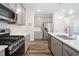 Bright kitchen with gray cabinets, stainless steel appliances, and light countertops at 1008 Ashton Oak Ct, Durham, NC 27703