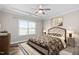Comfortable main bedroom featuring tray ceiling, ceiling fan and patterned bedding at 1008 Ashton Oak Ct, Durham, NC 27703