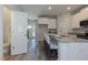 Kitchen with island, white cabinets, and view into hallway and bathroom at 1741 Old Fields Blvd, Haw River, NC 27258