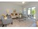 Spacious living room featuring a neutral color palette, plush seating, and a view of the backyard at 1741 Old Fields Blvd, Haw River, NC 27258