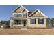 Two-story house with beige siding, black shutters, and a front porch at 181 Sage Ln, Four Oaks, NC 27524