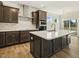 Modern kitchen with dark cabinetry, quartz countertops, and a large island at 181 Sage Ln, Four Oaks, NC 27524