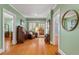 Light-filled hallway with hardwood floors and vintage furniture at 210 Woodburn Rd, Raleigh, NC 27605