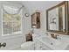 Bright bathroom with single vanity, toilet, and window at 225 Rudd Rd, Youngsville, NC 27596