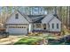 White farmhouse exterior with attached garage and landscaping at 225 Rudd Rd, Youngsville, NC 27596