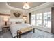 Luxurious main bedroom with tray ceiling, large windows, and ample natural light at 242 Broomside Ave, Raleigh, NC 27603