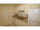 White kitchen cabinets, granite counters, and stainless steel appliances at 2530 Friedland Pl # 104, Raleigh, NC 27617