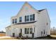 Two-story white farmhouse with black accents, two-car garage, and landscaping at 35 Mable Court # 3, Lillington, NC 27546