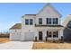 Two-story white farmhouse with black accents, two-car garage, and landscaping at 35 Mable Court # 3, Lillington, NC 27546