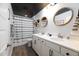 Bright bathroom with double vanity, wood-look floors, and shower with curtain at 147 E Wellesley Dr, Clayton, NC 27520