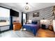 Stylish bedroom featuring a brick accent wall, wood floors, and a window providing natural light at 147 E Wellesley Dr, Clayton, NC 27520