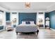 Blue Primary bedroom with tray ceiling, accent chair, and large windows at 147 E Wellesley Dr, Clayton, NC 27520