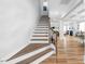 Elegant staircase featuring hardwood stairs and iron railing leading to the upper level at 147 E Wellesley Dr, Clayton, NC 27520