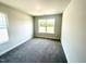Carpeted bedroom featuring a large window letting in plenty of natural light at 203 Lake Edge Dr, Lillington, NC 27546