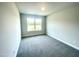 Well-lit bedroom with neutral paint, plush carpeting, and a large window offering natural light at 203 Lake Edge Dr, Lillington, NC 27546