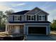 Two-story home featuring stone accents, a two car garage and black shutters on the windows at 203 Lake Edge Dr, Lillington, NC 27546